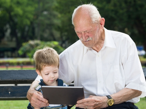 Family Fellowship teaser image: older mand and young boy looking at an Ipad