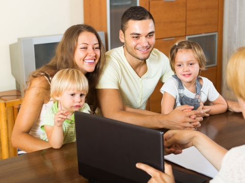Family Resource Specialist image: mother, father and two children looking at a laptop