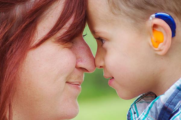 Support Groups image: mother and son with a hearing aid looking at each other